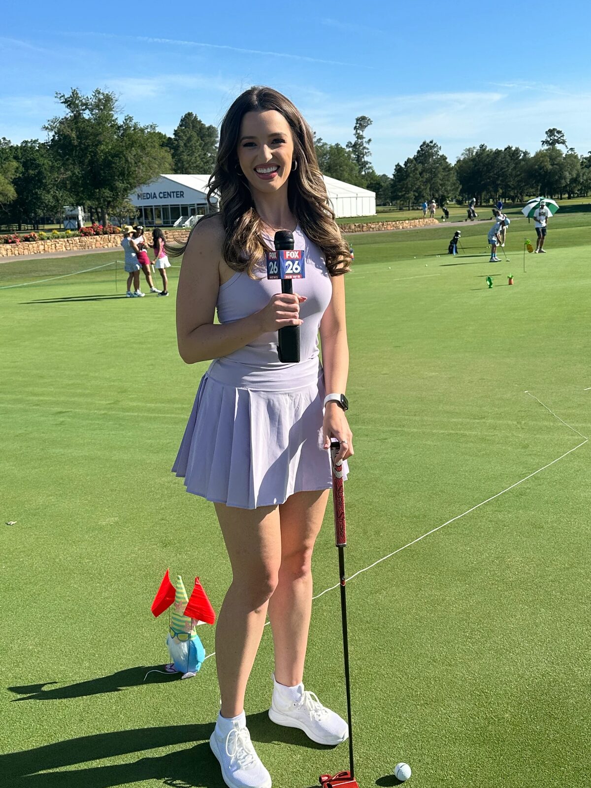 Broadcast reporter on course at a golf activation